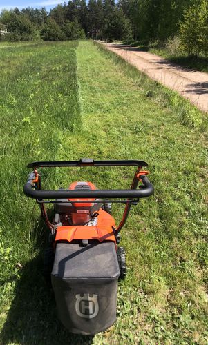 Aukštos žolės pjovimas trimeriu. Žolės pjovimas žoliapjove ir sodų traktoriukų.